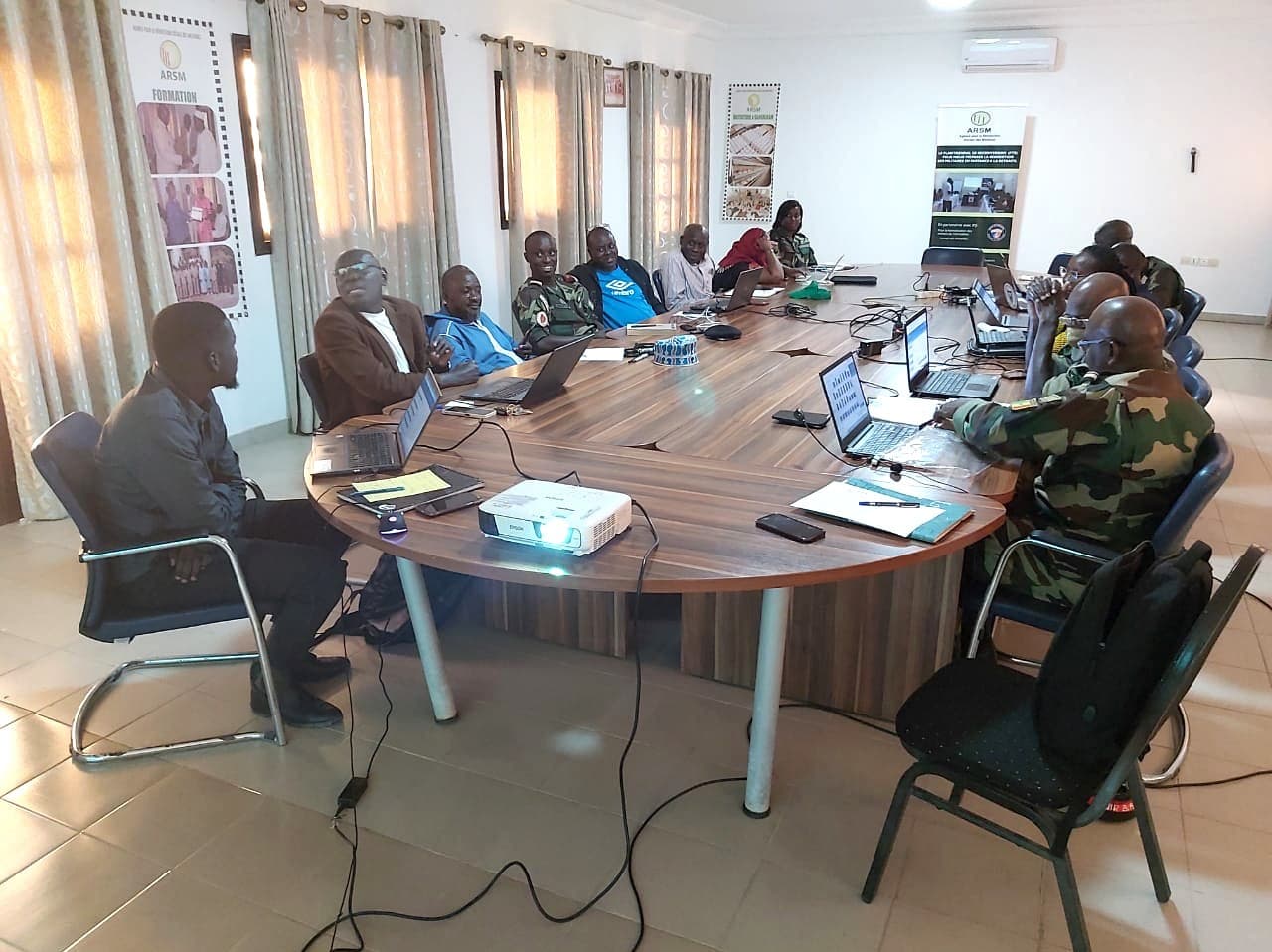 Formation au logiciel RH-ARSM à Dakar, en mars 2023 : participants en tenue militaire et civile autour d'une table, ordinateurs ouverts